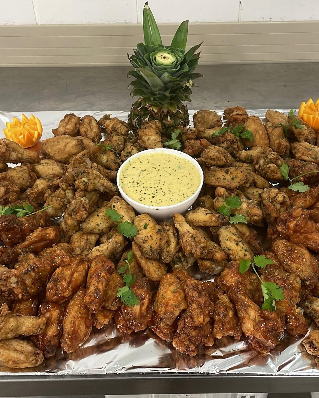 Platter of seasoned and glazed chicken wings with a creamy dip